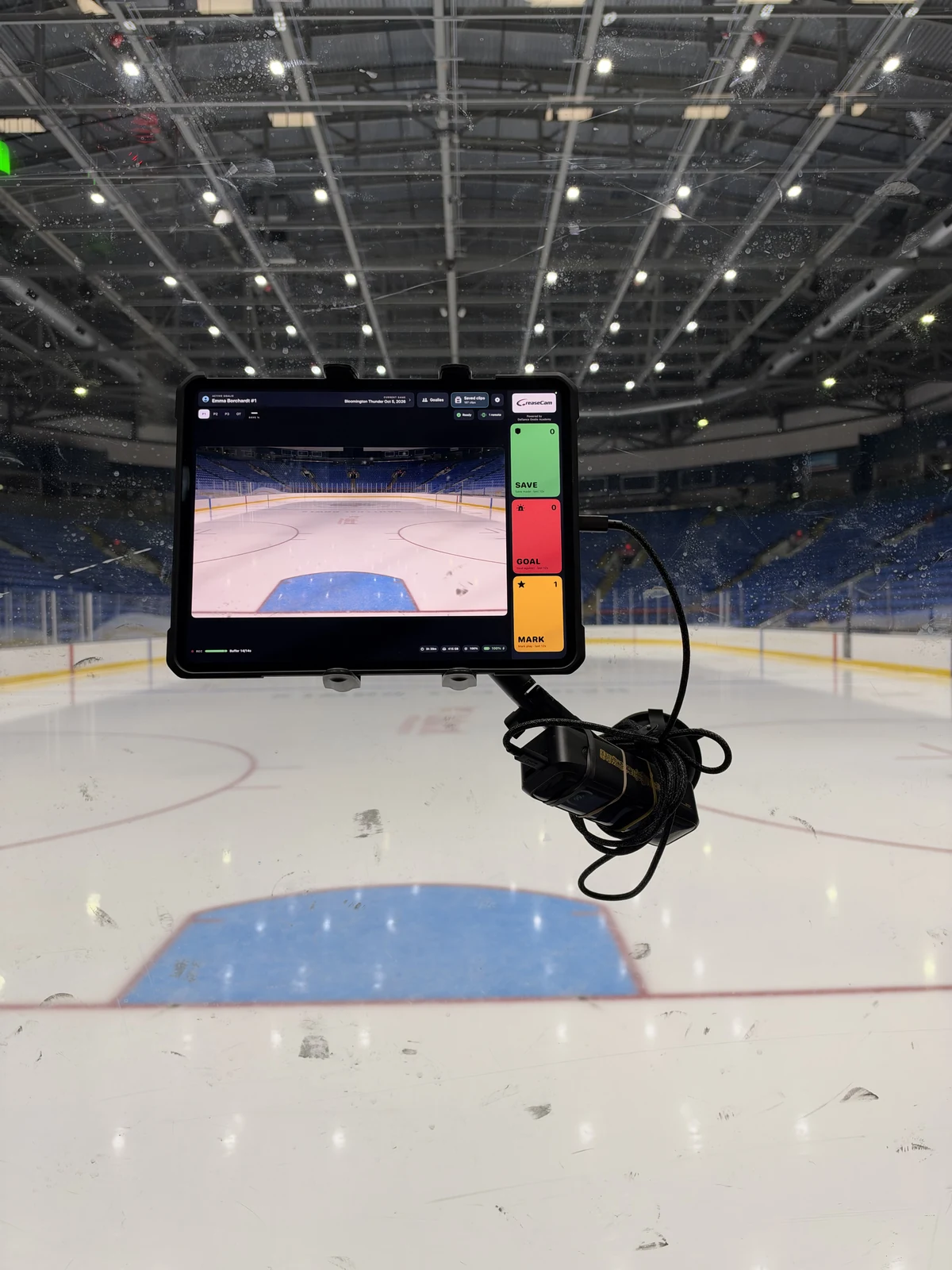 A real iPad camera mounted on rink glass behind the net.